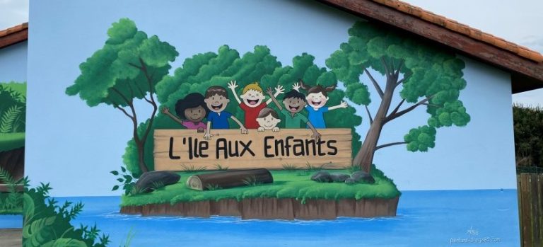 Mural représentant des enfants souriants avec le texte "L'île aux enfants" en bois.