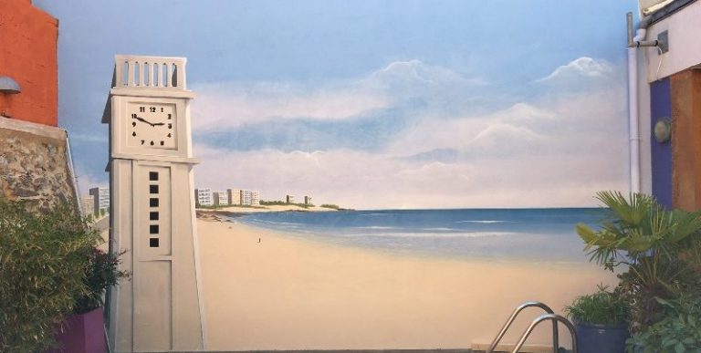 Une horloge à côté d'une plage et d'un paysage côtier serein.