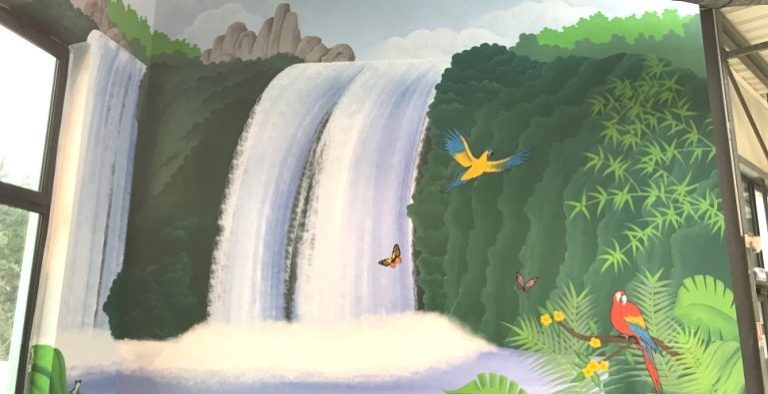Murale représentant des cascades entourées de verdure et d'oiseaux colorés.