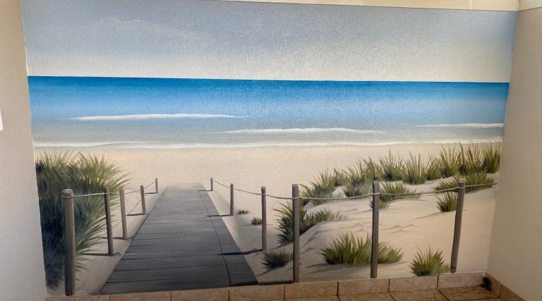 Trompe oeil d'un Chemin en bois menant à une plage de sable, avec des dunes et une mer calme.